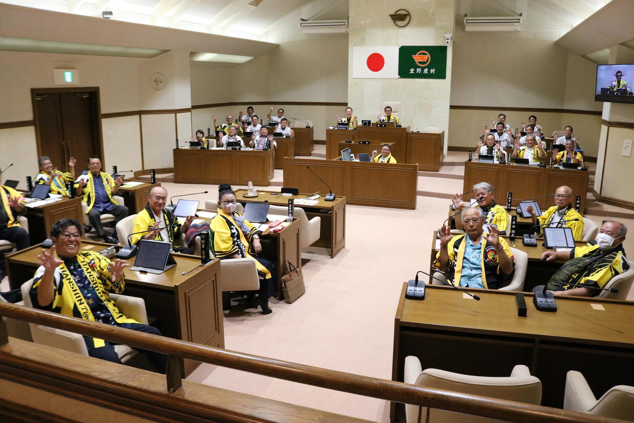 宜野座村議会に出席した村長や議長らが阪神の法被を着用して虎ポーズで笑顔を見せる（撮影・林亮佑）