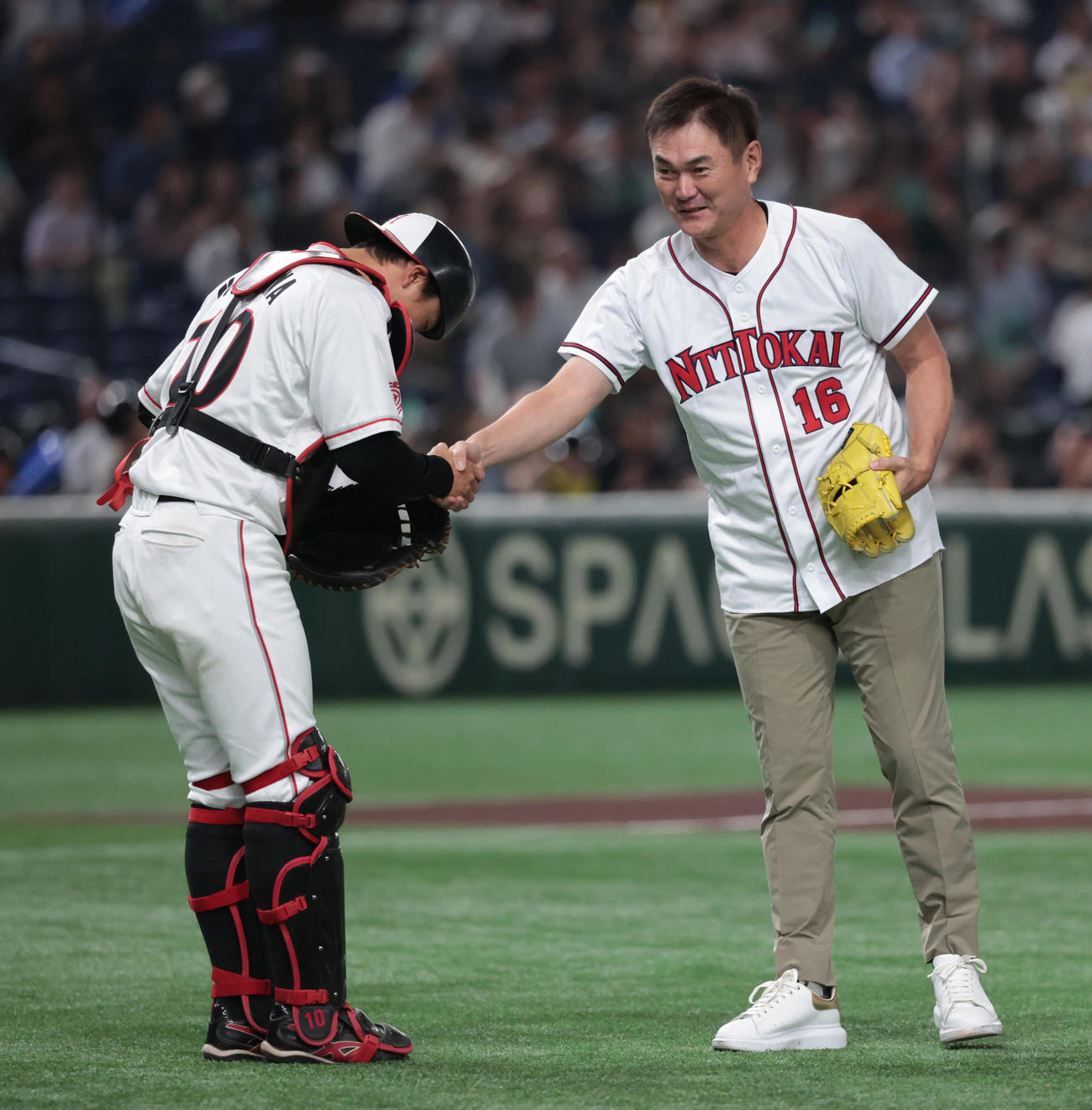 王子対三菱自動車岡崎の決勝戦、NTT東海のユニホームで始球式を務めた元中日の岩瀬仁紀氏（右）は三菱自動車岡崎・西川捕手と握手する（撮影・柴田隆二）　