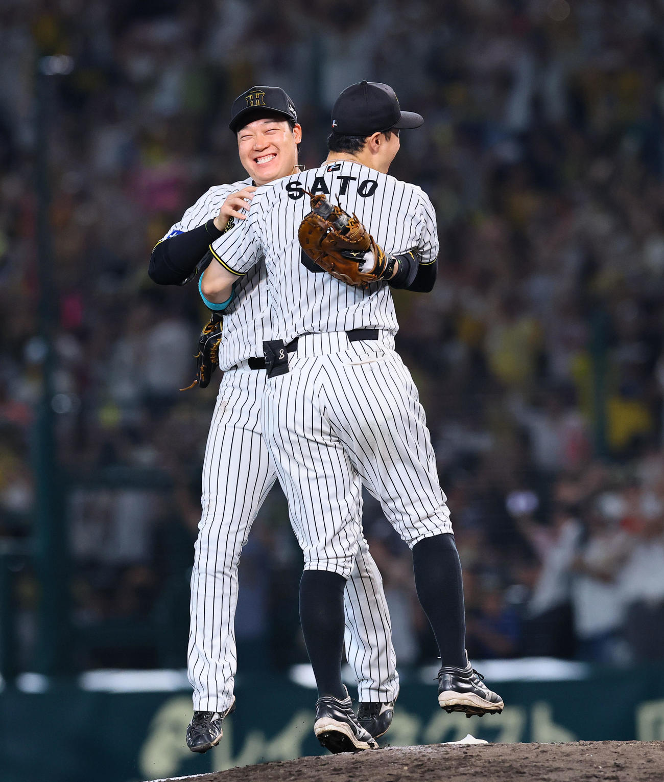 リーグ優勝を決め、大山と抱き合って喜ぶ佐藤輝
