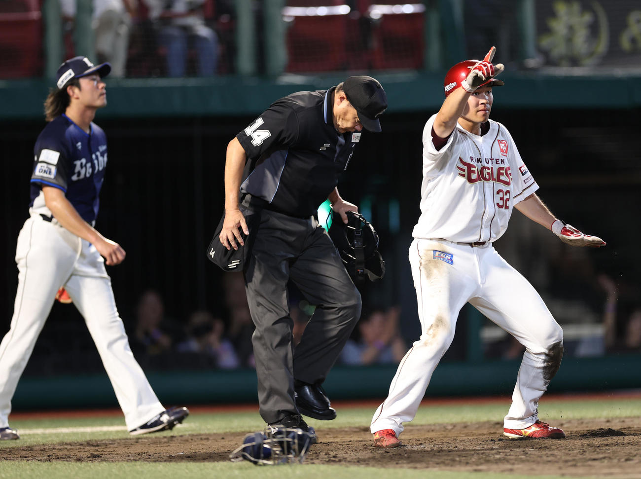楽天対西武　2回裏楽天1死一、二塁、黒川の適時打で生還しポーズをとる中島。後方は西武今井（撮影・水谷安孝）