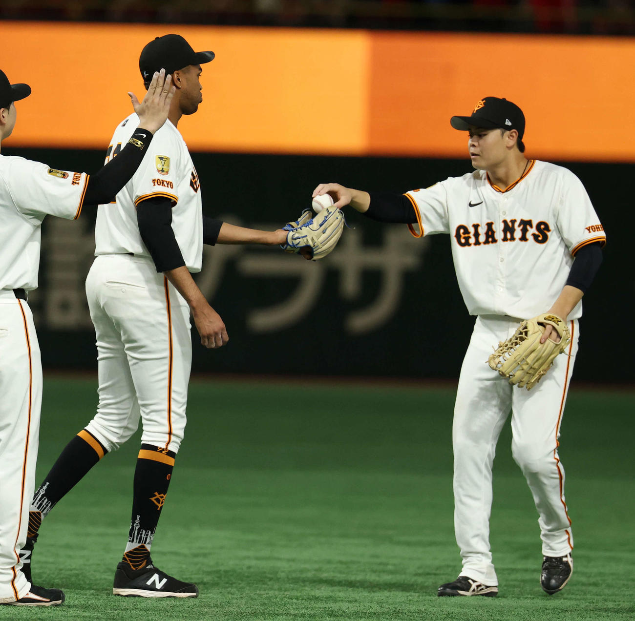 巨人対広島　9回表広島を抑えて40セーブ達成したマルティネス（左）は中山からボールを受け取る（撮影・浅見桂子）