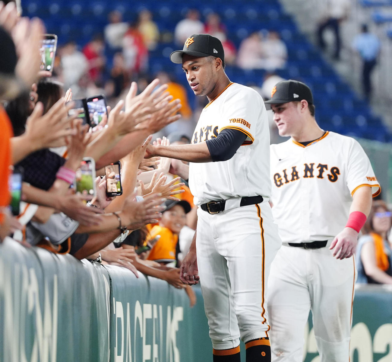 巨人対広島　試合後、ファンとタッチを交わす巨人マルティネス（手前）とリチャード（撮影・江口和貴）