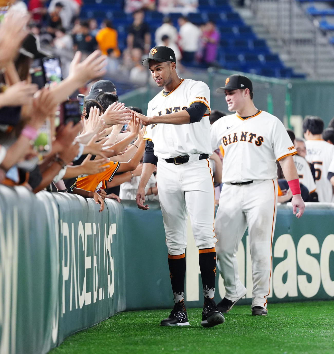 巨人対広島　試合後、ファンとタッチを交わす巨人マルティネス（手前）とリチャード（撮影・江口和貴）