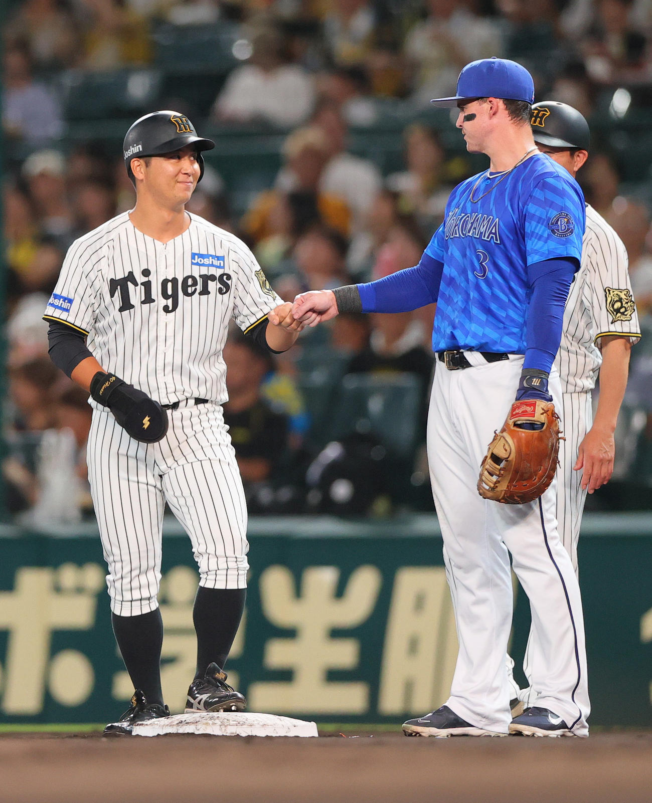 阪神対DeNA 2回裏阪神1死、左前打を放った井坪（左）を祝福する一塁手オースティン（撮影・上山淳一）