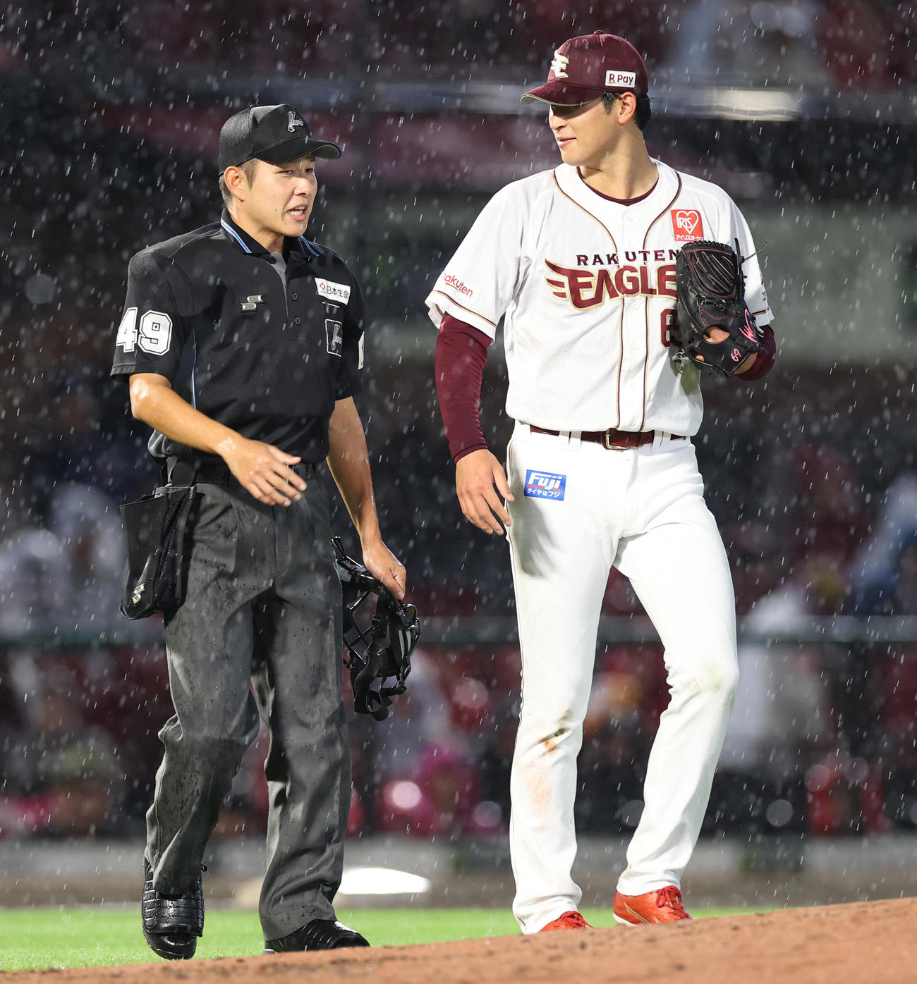 楽天対西武　3回表、雨足が強くなり球審と話をしながらマウンドに向かう内（撮影・水谷安孝）