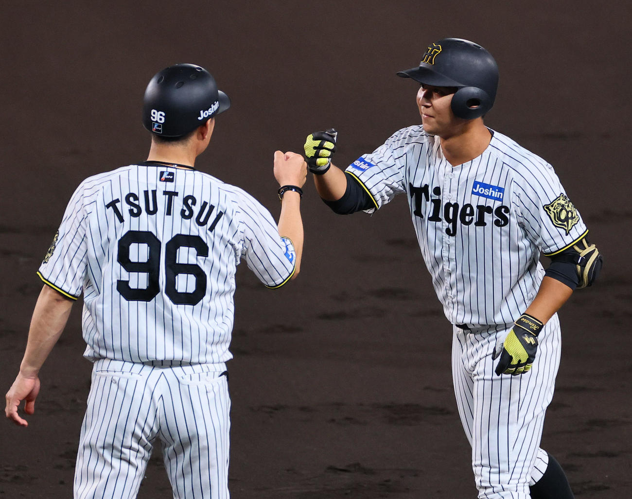 阪神対DeNA 2回裏阪神1死、井坪は安打を放ちタッチを交わす（撮影・藤尾明華）