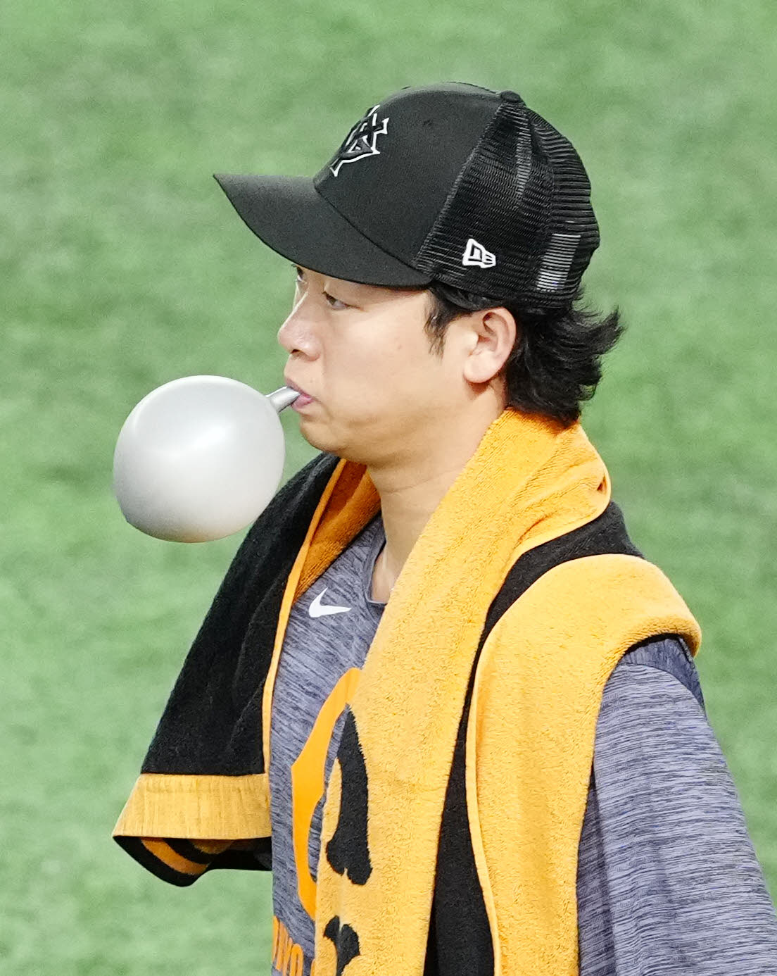 巨人対広島　試合前練習を終え、風船を膨らませながらグラウンドから引き揚げる巨人山崎（撮影・江口和貴）