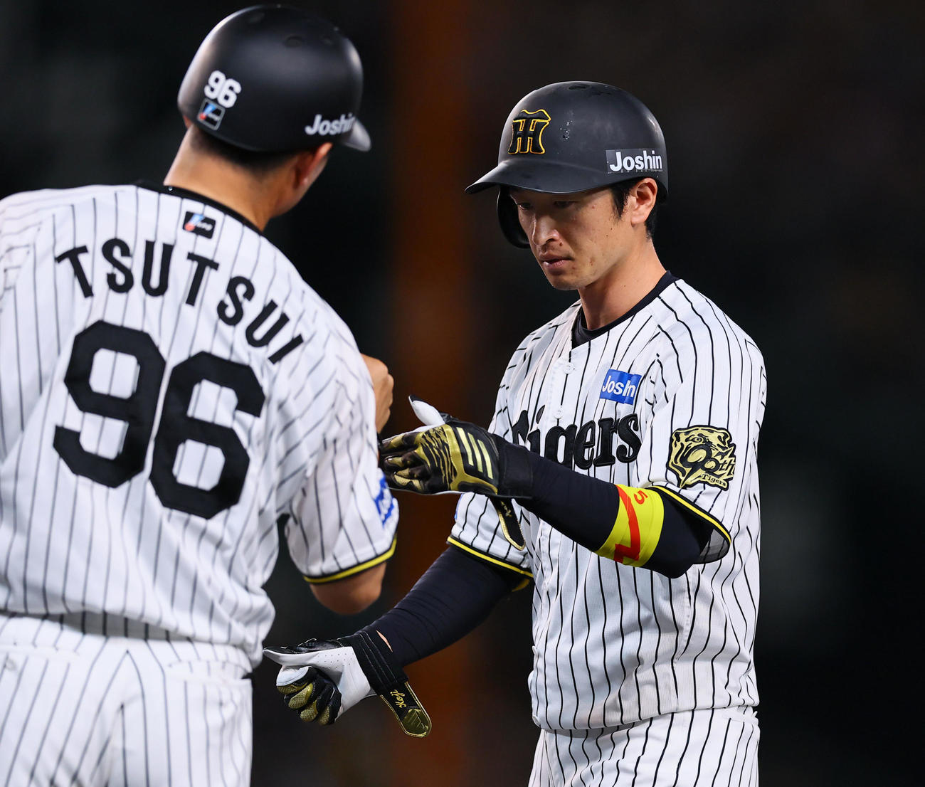 阪神対DeNA 4回裏阪神無死、近本は左前打を放ちタッチを交わす（撮影・藤尾明華）