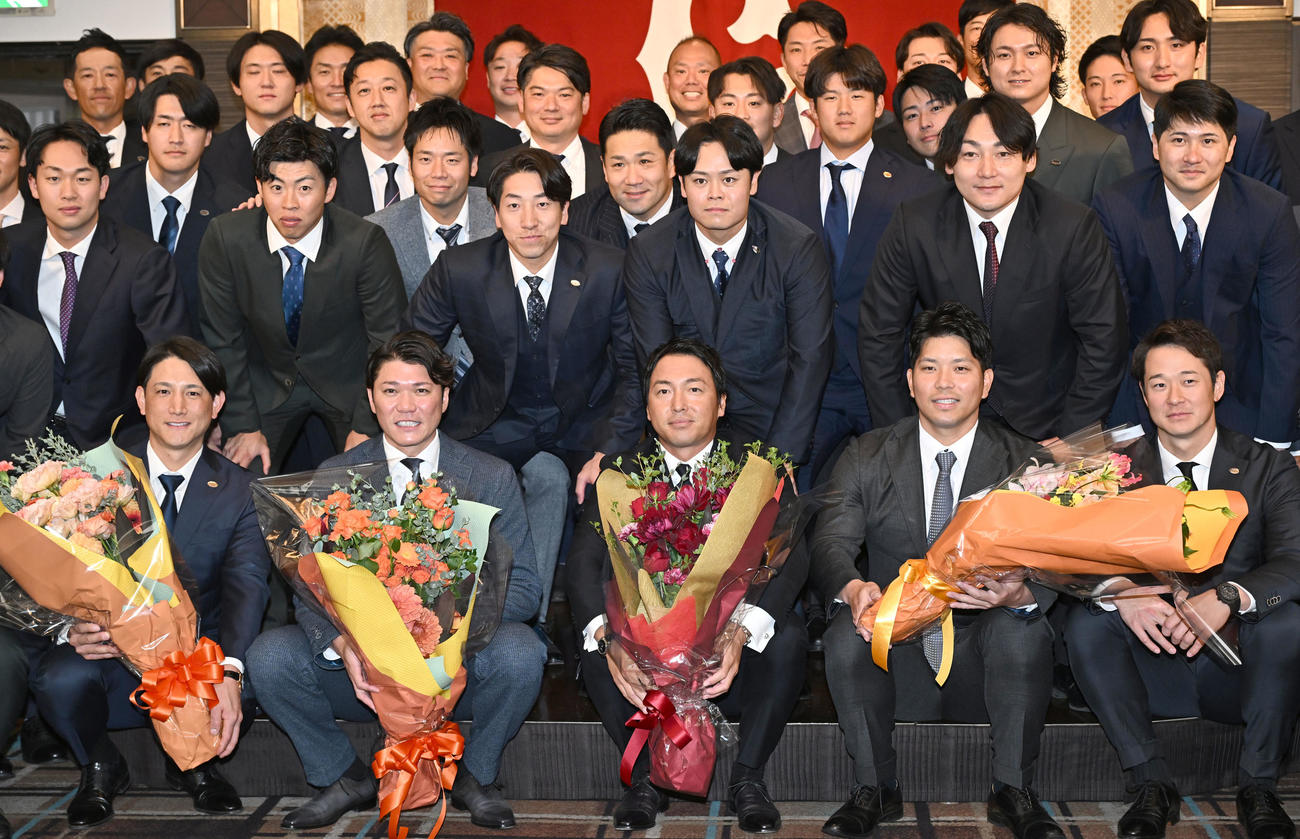 現役引退記者会見に駆けつけた選手やコーチらと記念撮影に臨む巨人長野外野手（前列中央）（撮影・千葉一成）
