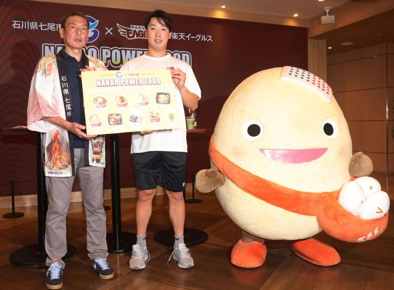 石川県七尾市の食材を使用した「NANAO POWER FOOD」の販売会見に登場し、七尾市の中村産業部長（左）、和倉温泉のキャラクターわくたまくん（右）と記念撮影する楽天藤平（撮影・野上伸悟）