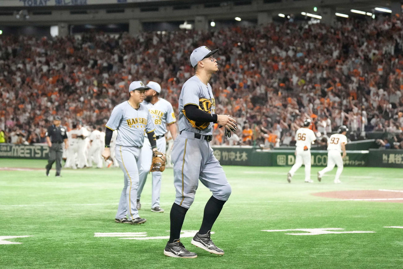 巨人対阪神　サヨナラ負けで引き揚げる佐藤輝。後方右はドリス、同左は大山（撮影・井上学）