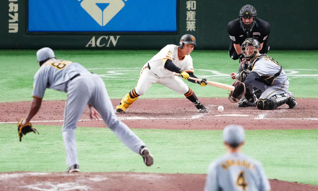 巨人対阪神　9回裏巨人無死一、二塁、送りバントを決める浦田。投手ドリス（撮影・鈴木みどり）