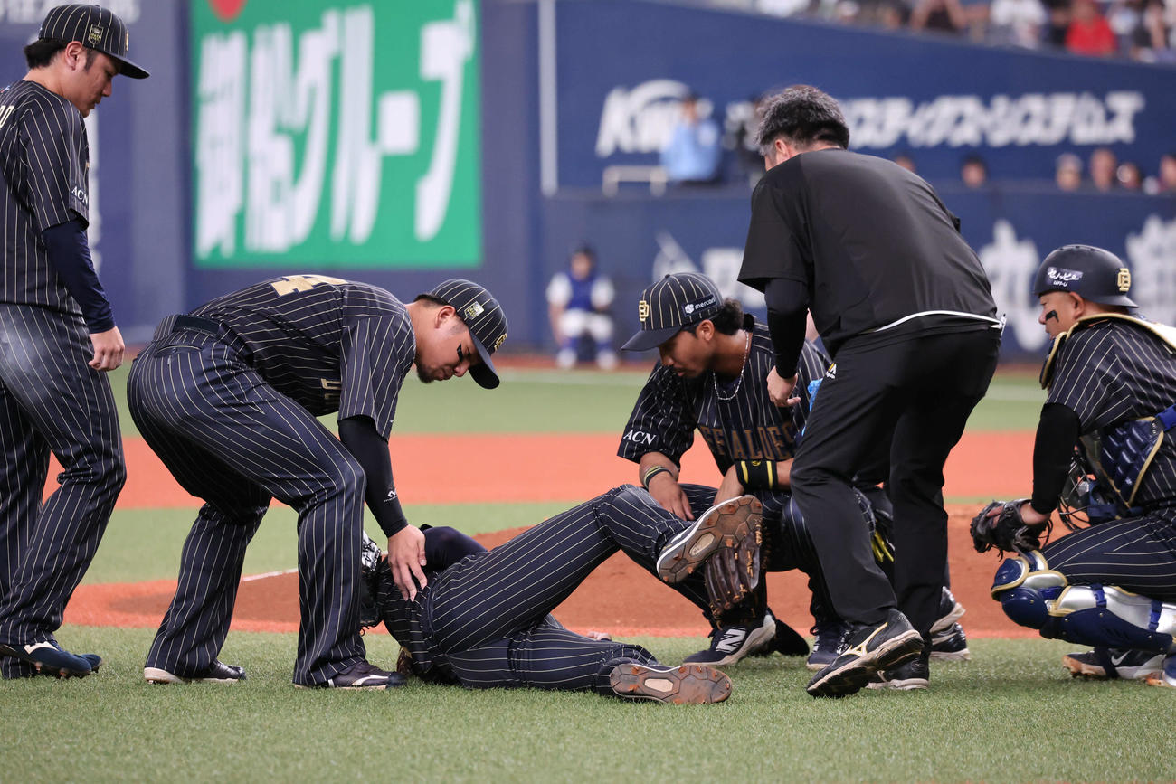 オリックス対ソフトバンク　2回表ソフトバンク2死一、二塁、海野の折れたバットが当たり苦悶の表情で倒れ込む曽谷に駆け寄る内野陣（撮影・西尾就之）