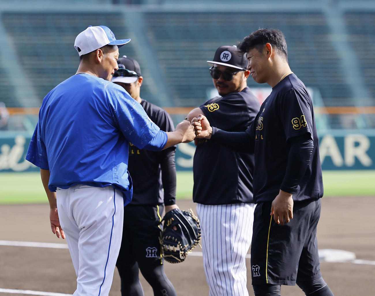 阪神対中日　引退を発表した中日中田（左）とタッチを交わす阪神原口（撮影・藤尾明華）
