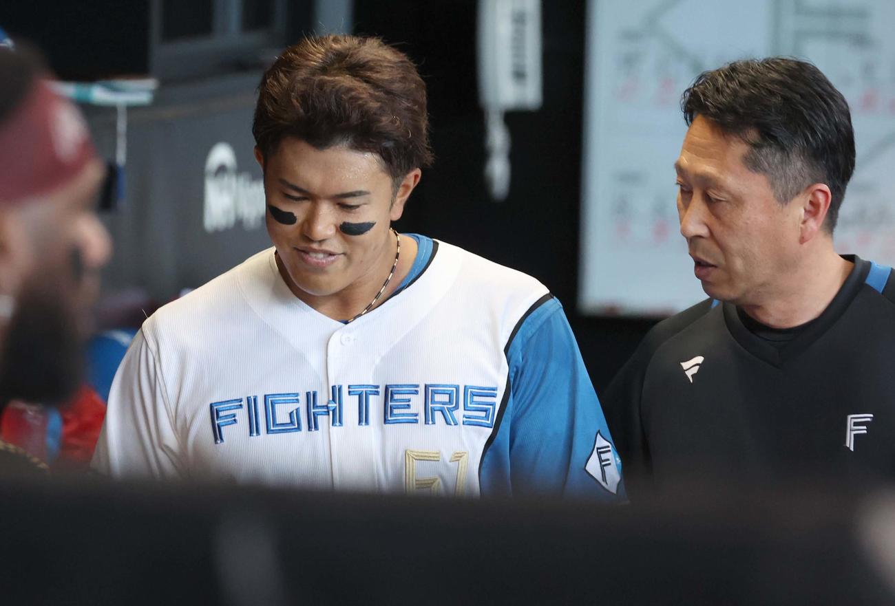 日本ハム対西武　5回裏終了時、トレーナーと話しながらベンチ裏に引き揚げる今川（撮影・黒川智章）