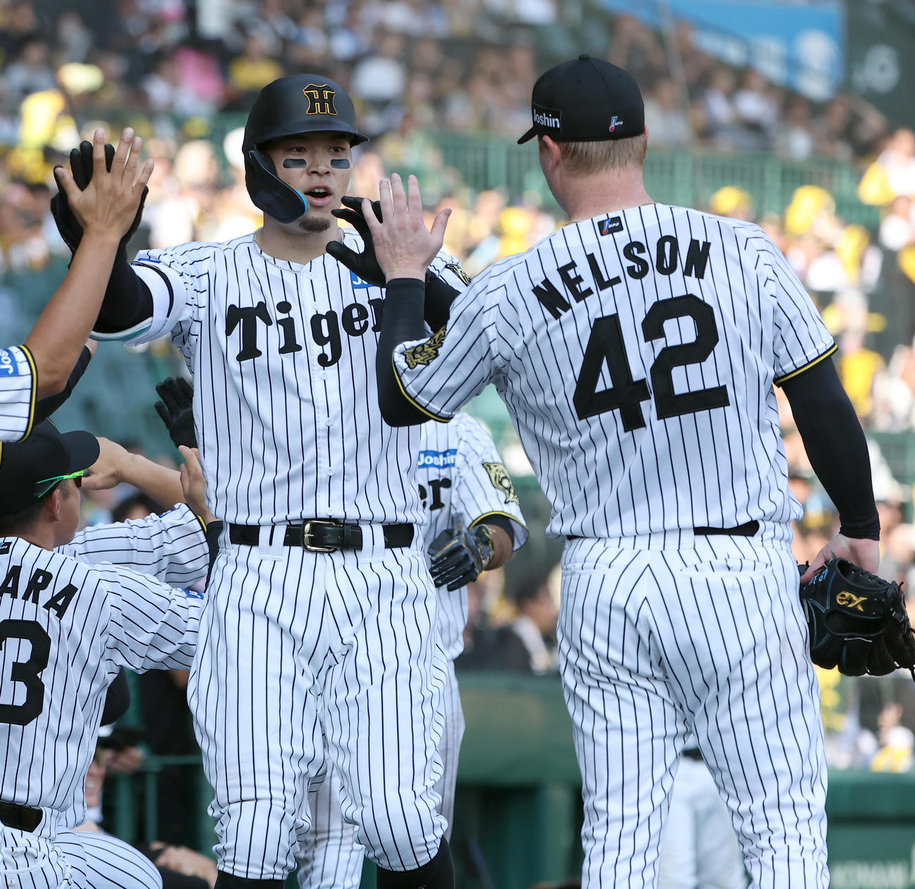 阪神対中日　3回裏阪神1死一塁、2点本塁打を放った佐藤輝（左）は先発ネルソンとハイタッチをする（撮影・上田博志）