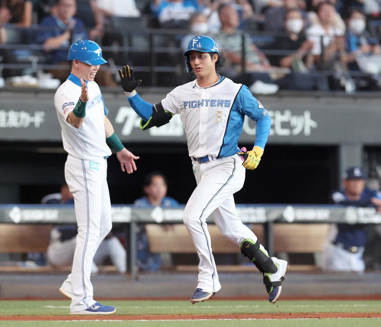 日本ハム対西武　6回裏日本ハム2死一、三塁、左越え3点本塁打を放ち森本コーチとタッチする浅間（撮影・黒川智章）