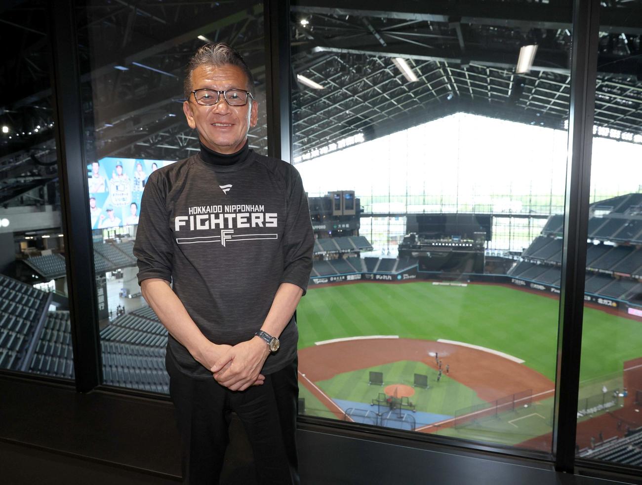 球場を背に笑顔の日本ハム小村球団社長