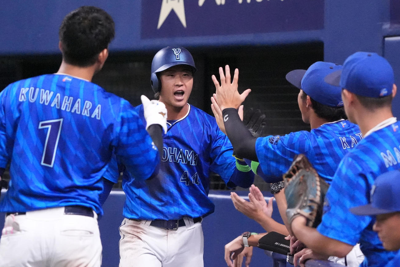中日対DeNA 7回表DeNA1死三塁、石上（左から2人目）は東のスクイズで生還しナインとタッチを交わす（撮影・森本幸一）