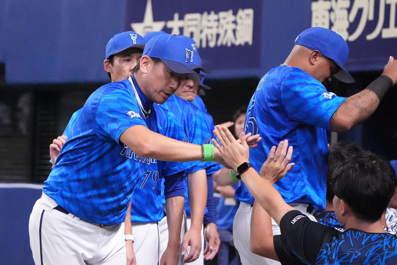 中日対DeNA　試合終了、三浦監督（左）はナイン、スタッフとタッチを交わす（撮影・森本幸一）