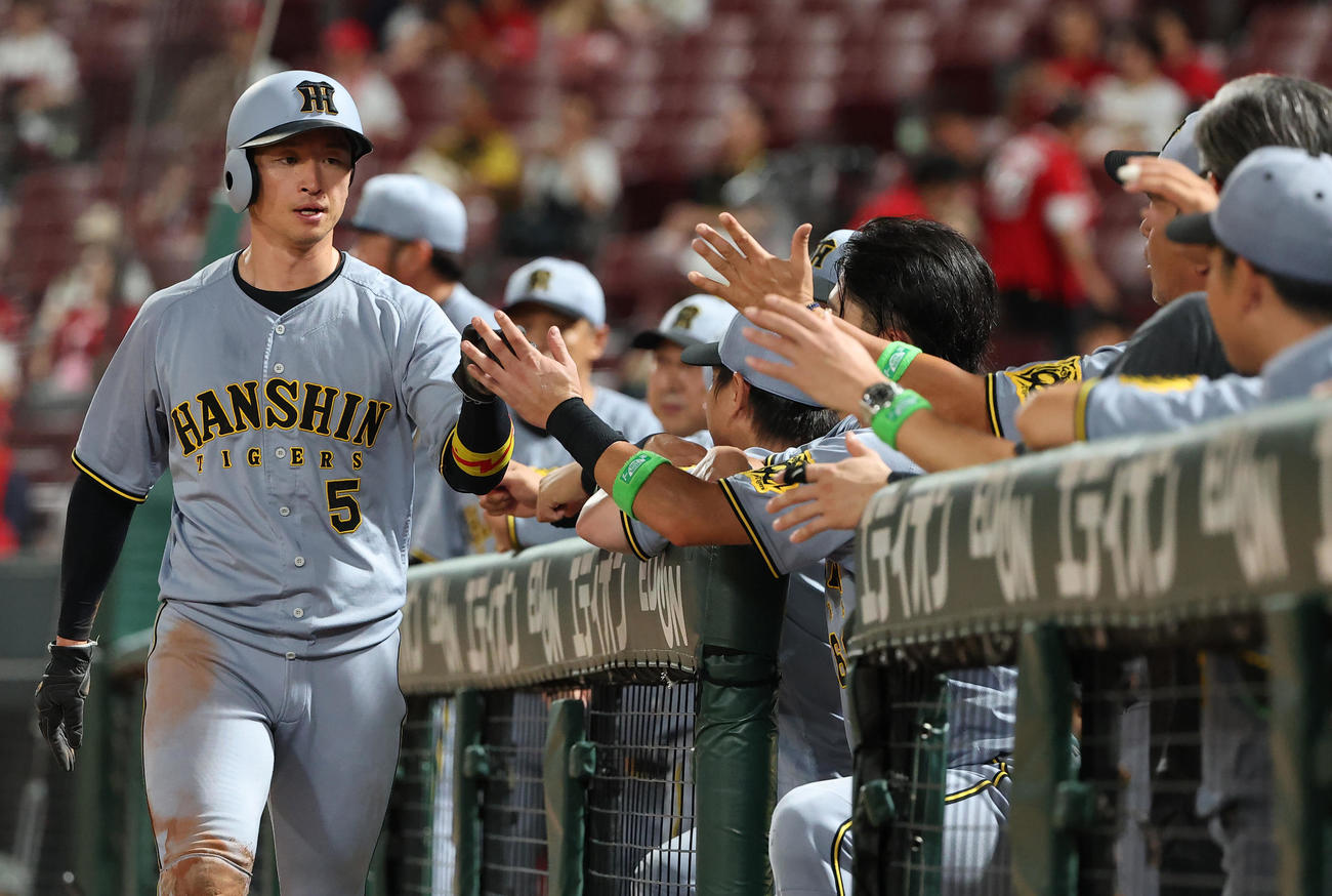 広島対阪神　9回表阪神2死二塁、森下の適時打で生還した近本はナインとハイタッチをする（撮影・上田博志）