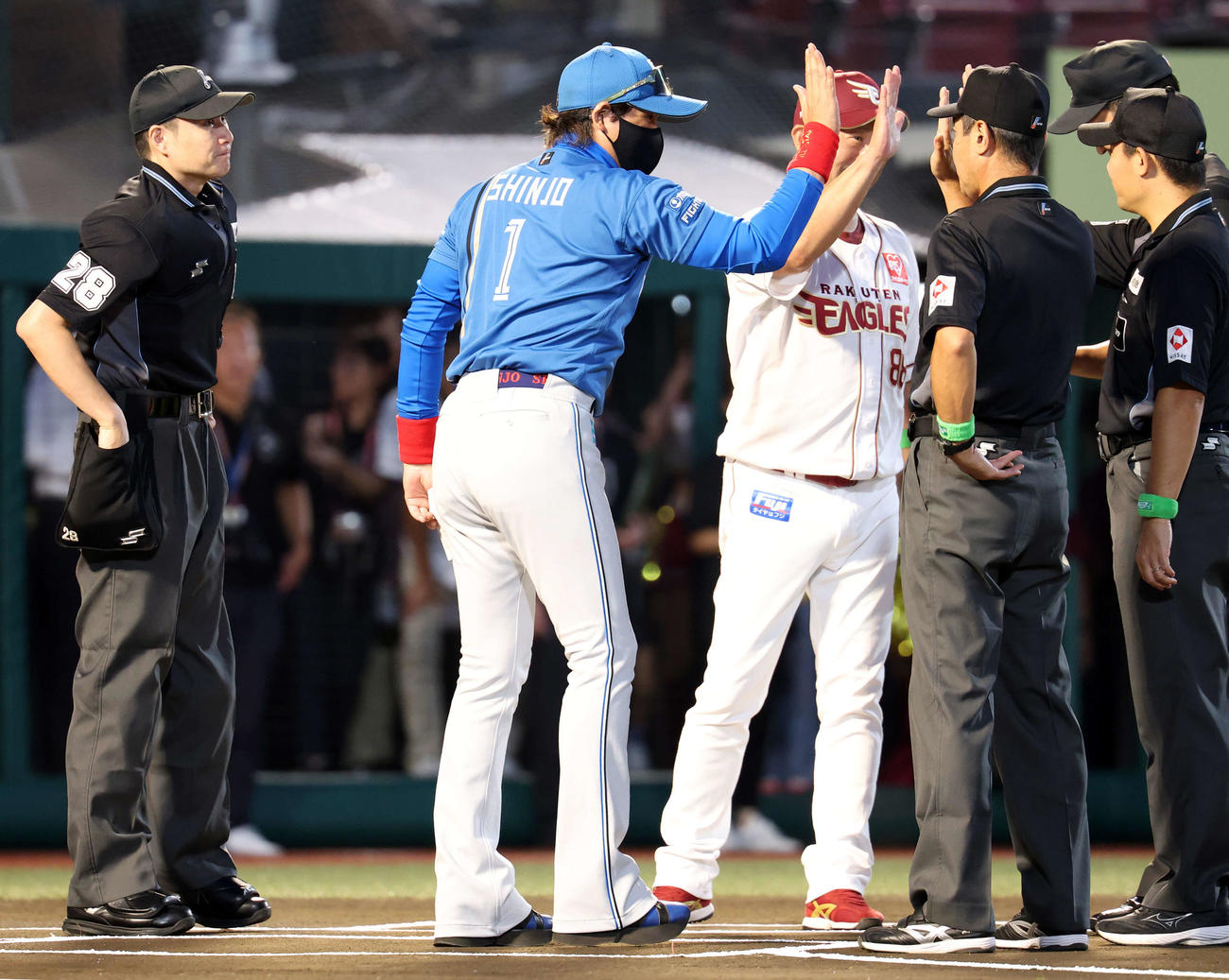 楽天対日本ハム　メンバー最終確認で日本ハム新庄監督（手前）は楽天三木監督、審判団とハイタッチ（撮影・浅見桂子）