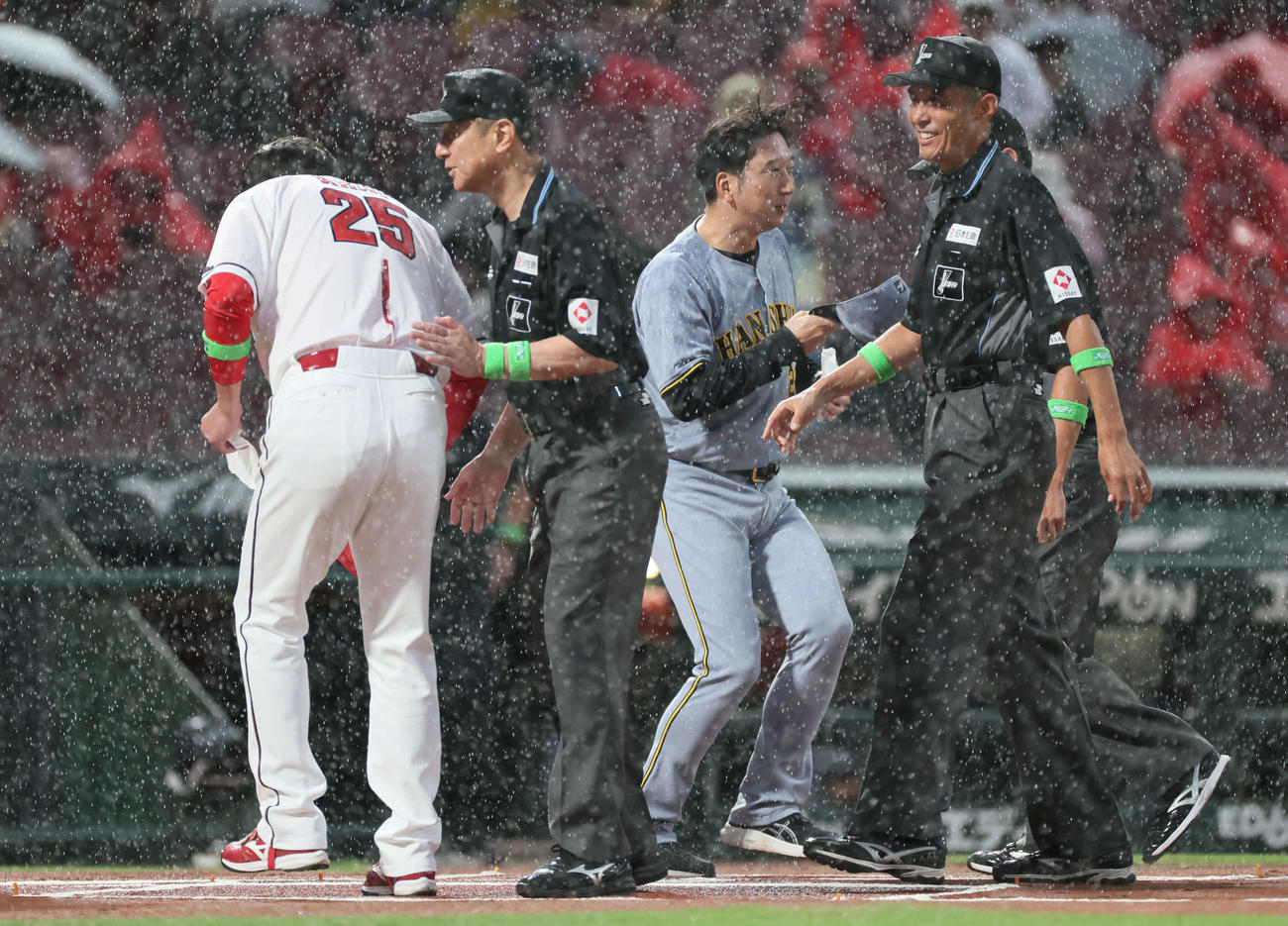 広島対阪神　土砂降りの中、メンバー表交換する広島新井監督と阪神藤川監督（撮影・加藤孝規）