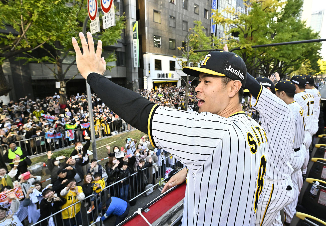 23年11月、大阪・御堂筋での優勝パレードで、手を振る阪神佐藤輝明