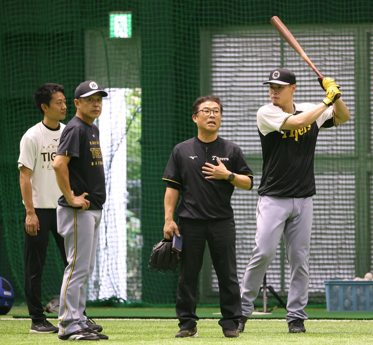 広島対阪神　佐藤輝（右）は藤本コーチ（左から2人目）トレーナーらと話をする（撮影・上田博志）