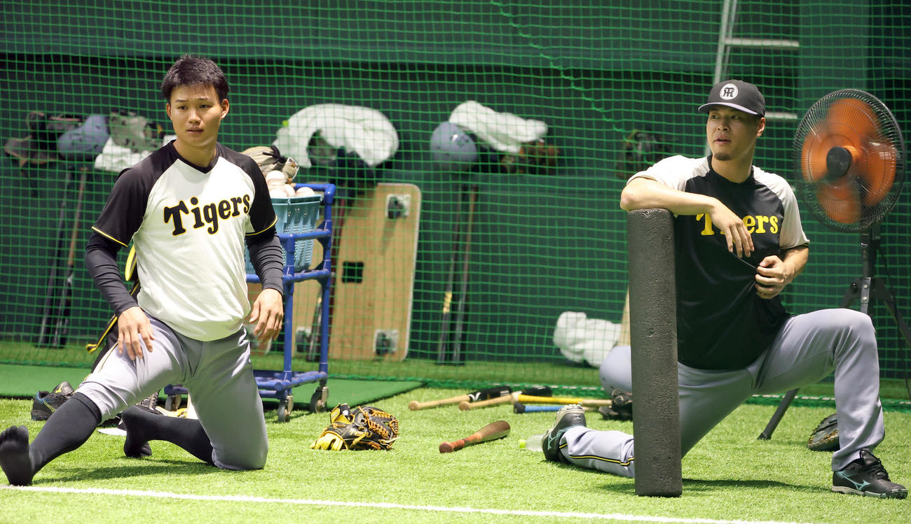 広島対阪神　室内練習場でストレッチをする森下（左）と佐藤輝（撮影・上田博志）