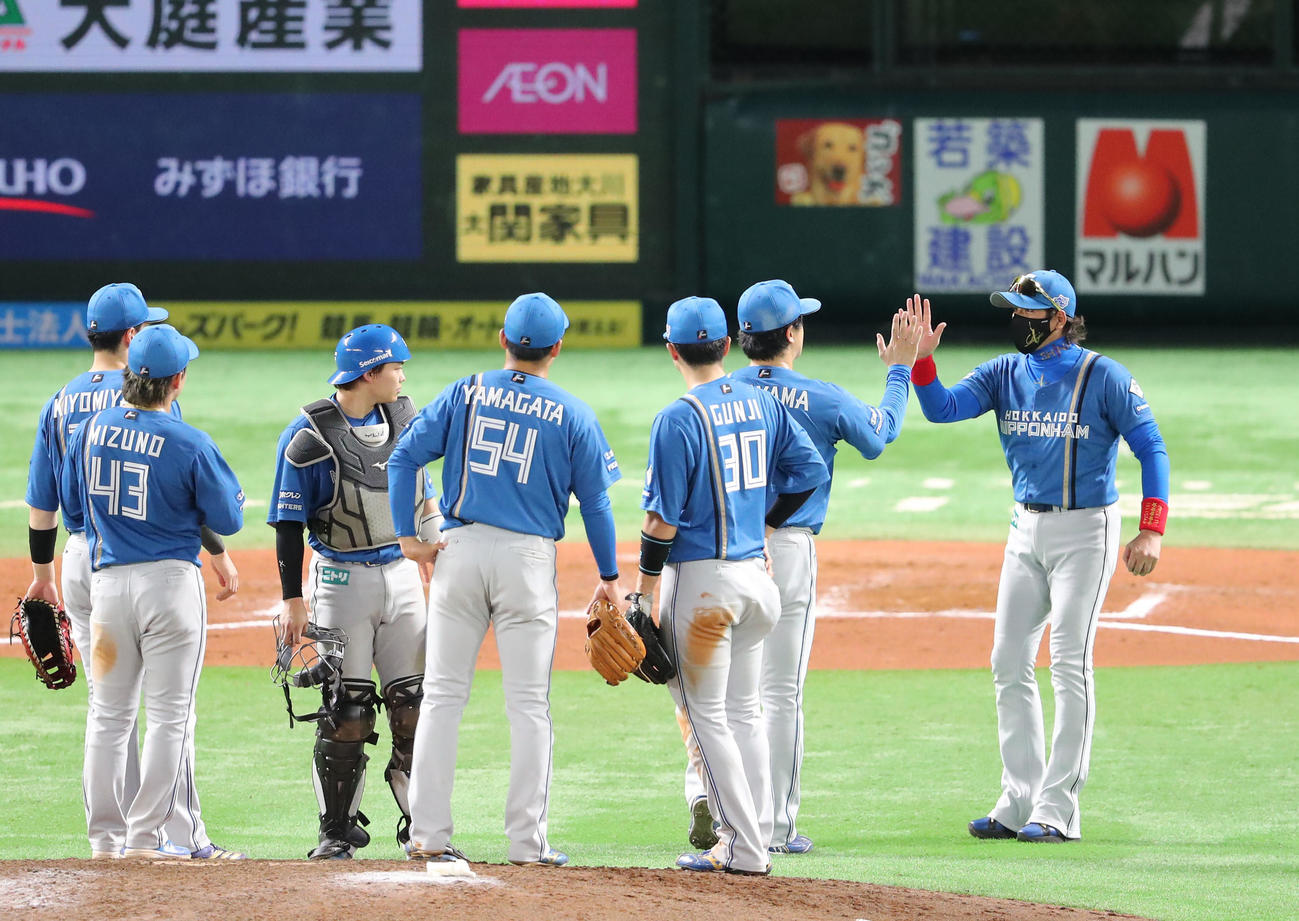 ソフトバンク対日本ハム　7回途中、投手交代でマウンドに向かった新庄監督は先発の北山とハイタッチ（撮影・梅根麻紀）