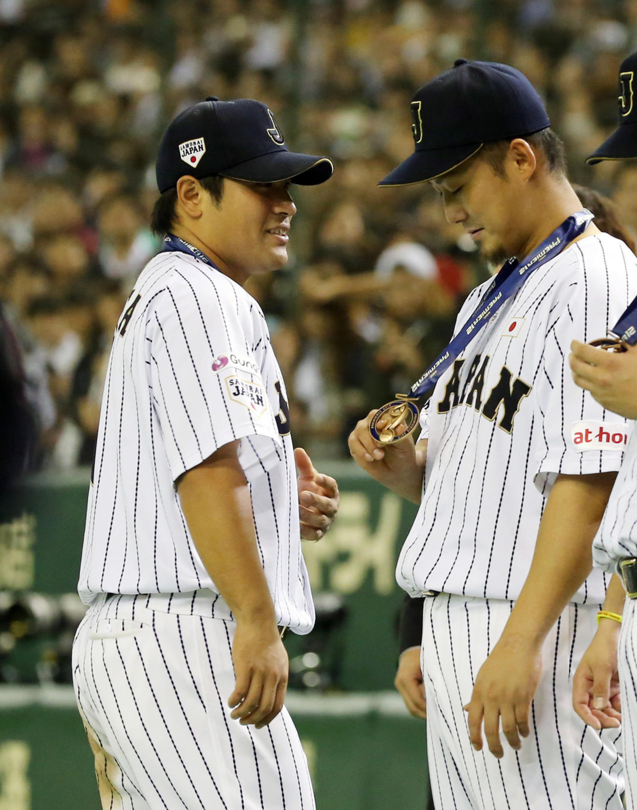 世界野球WBSCプレミア12の表彰式で銅メダルを見つめる、左2人目から中田。左端は平田＝15年11月