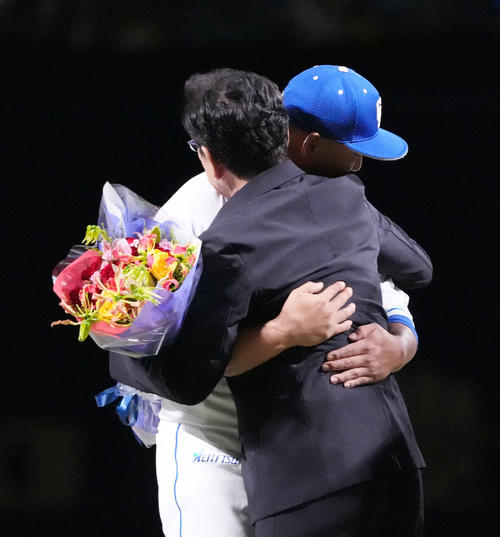 中日対ヤクルト 中田(左)は栗山英樹氏から花束を受け取りハグを交わす(撮影・森本幸一)