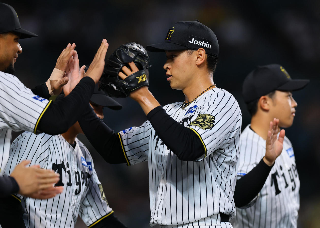 阪神対DeNA 1回表DeNA1死一、三塁、ビシエドを遊ゴロ併殺に打ち取りベンチのナインとタッチを交わす早川（撮影・藤尾明華）