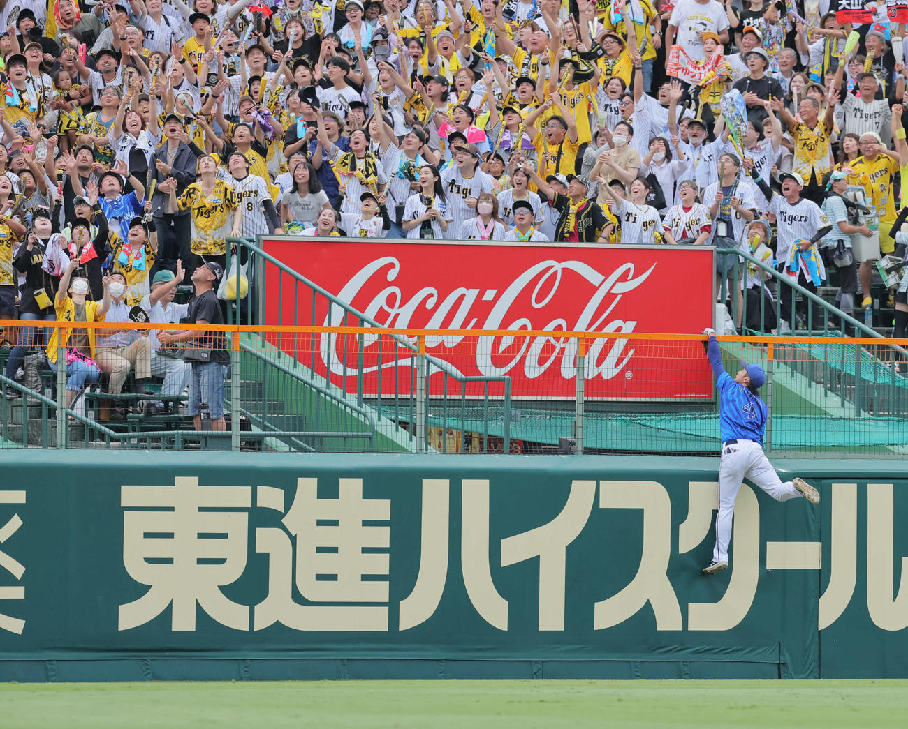 阪神対DeNA 7回裏阪神1死、度会は大山の左越え本塁打を追ってフェンスにぶら下がる（撮影・宮崎幸一）