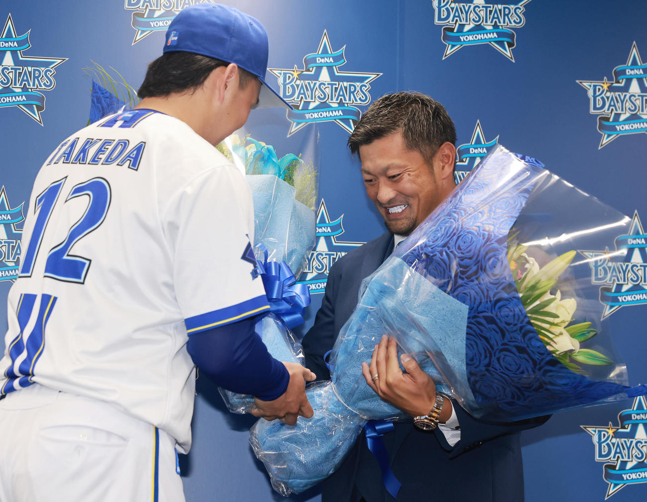 引退会見で竹田（左）から花束をもらうDeNA森唯（撮影・野上伸悟）