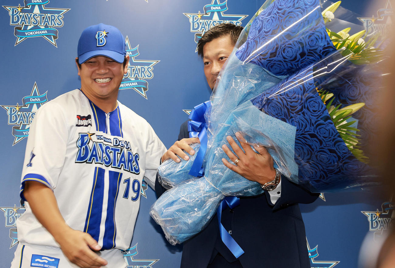 引退会見で山崎（左）から花束をもらうDeNA森唯（撮影・野上伸悟）