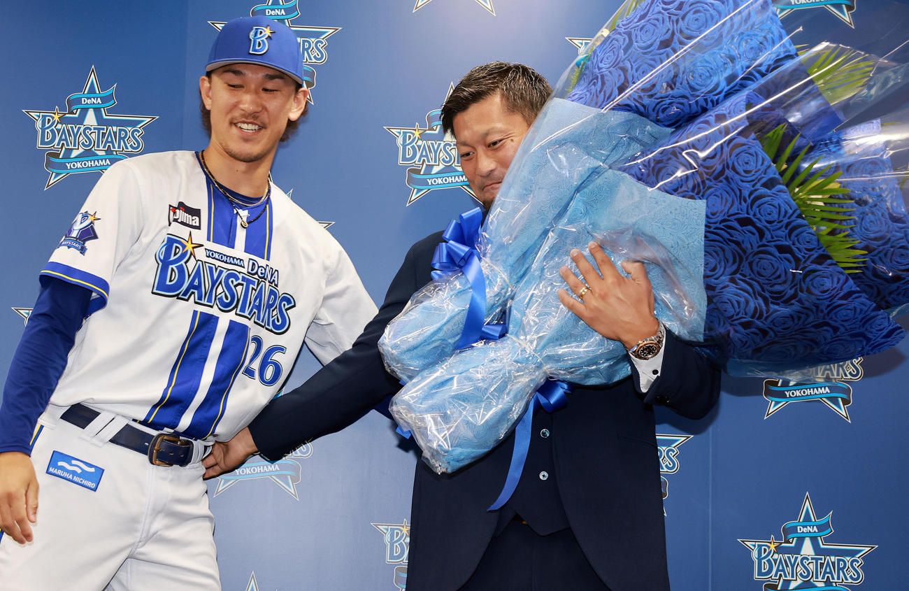 引退会見で三森（左）から花束をもらうDeNA森唯（撮影・野上伸悟）