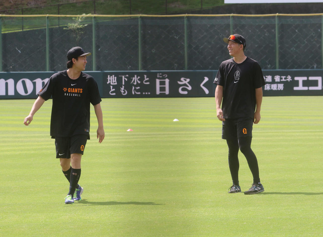 練習中に笑顔で会話を交わす戸郷と山崎（左）