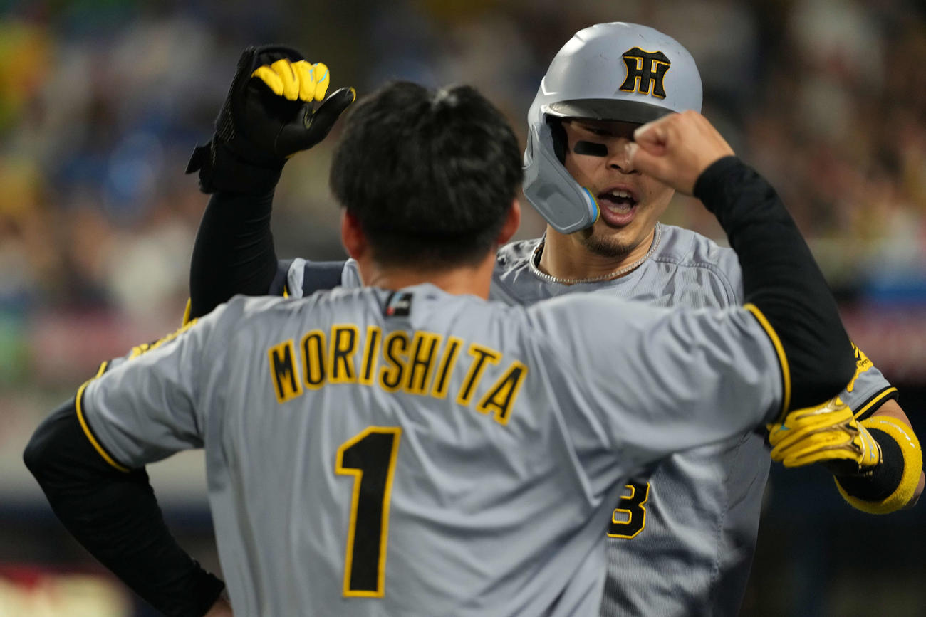 ヤクルト対阪神　左越え本塁打を放った佐藤輝（奥）は森下とハイタッチ（撮影・井上学）