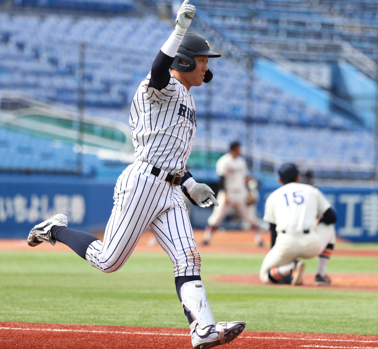 法大対立大　8回裏立大2死二塁、小林隼は左越えに決勝本塁打を放ちガッツポーズする。後方はがっくりする法大・丸山（撮影・柴田隆二）　　