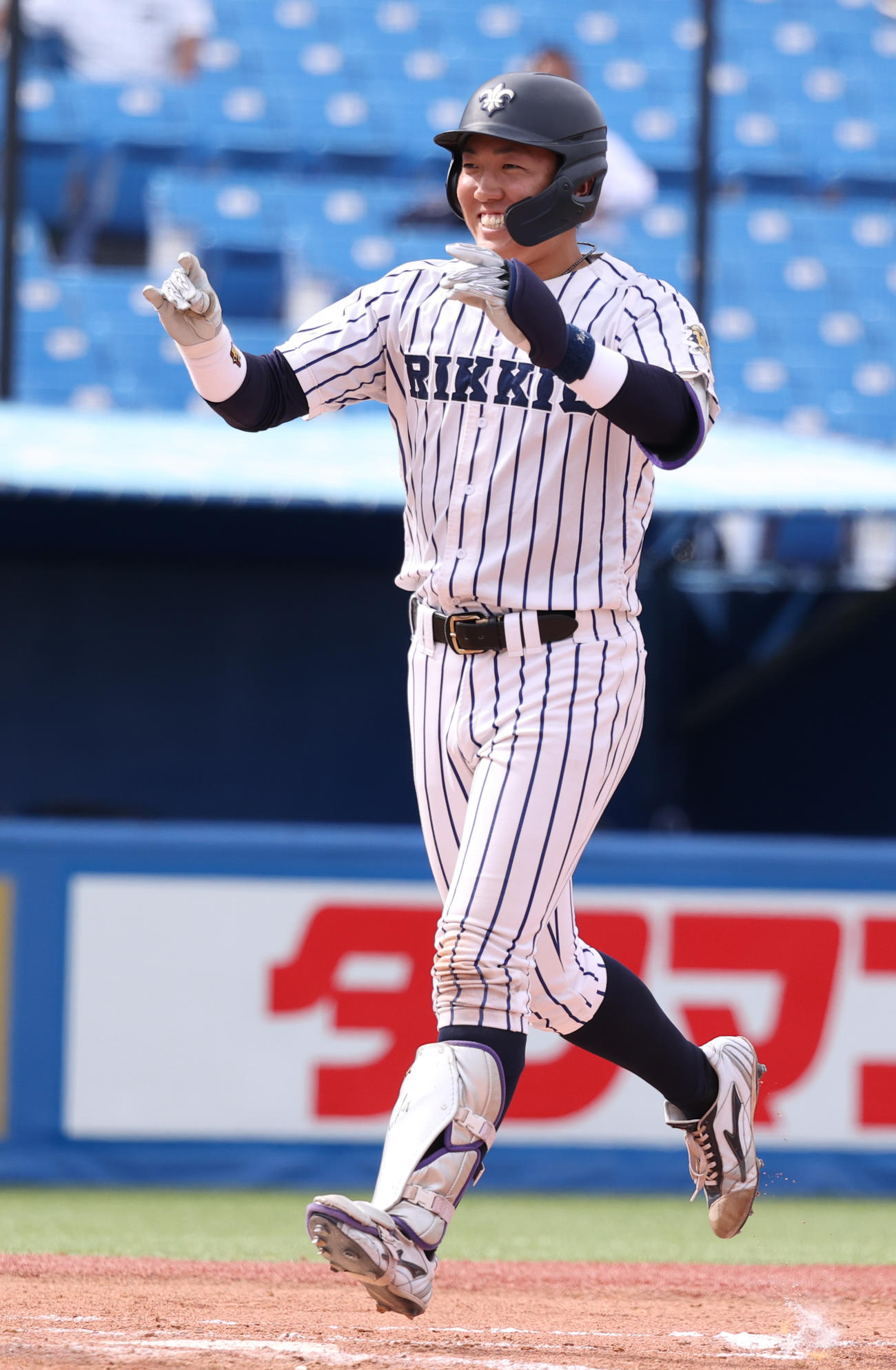 法大対立大　8回裏立大2死二塁、小林隼は左越えに決勝本塁打を放ちキツネポーズで生還する（撮影・柴田隆二）　　