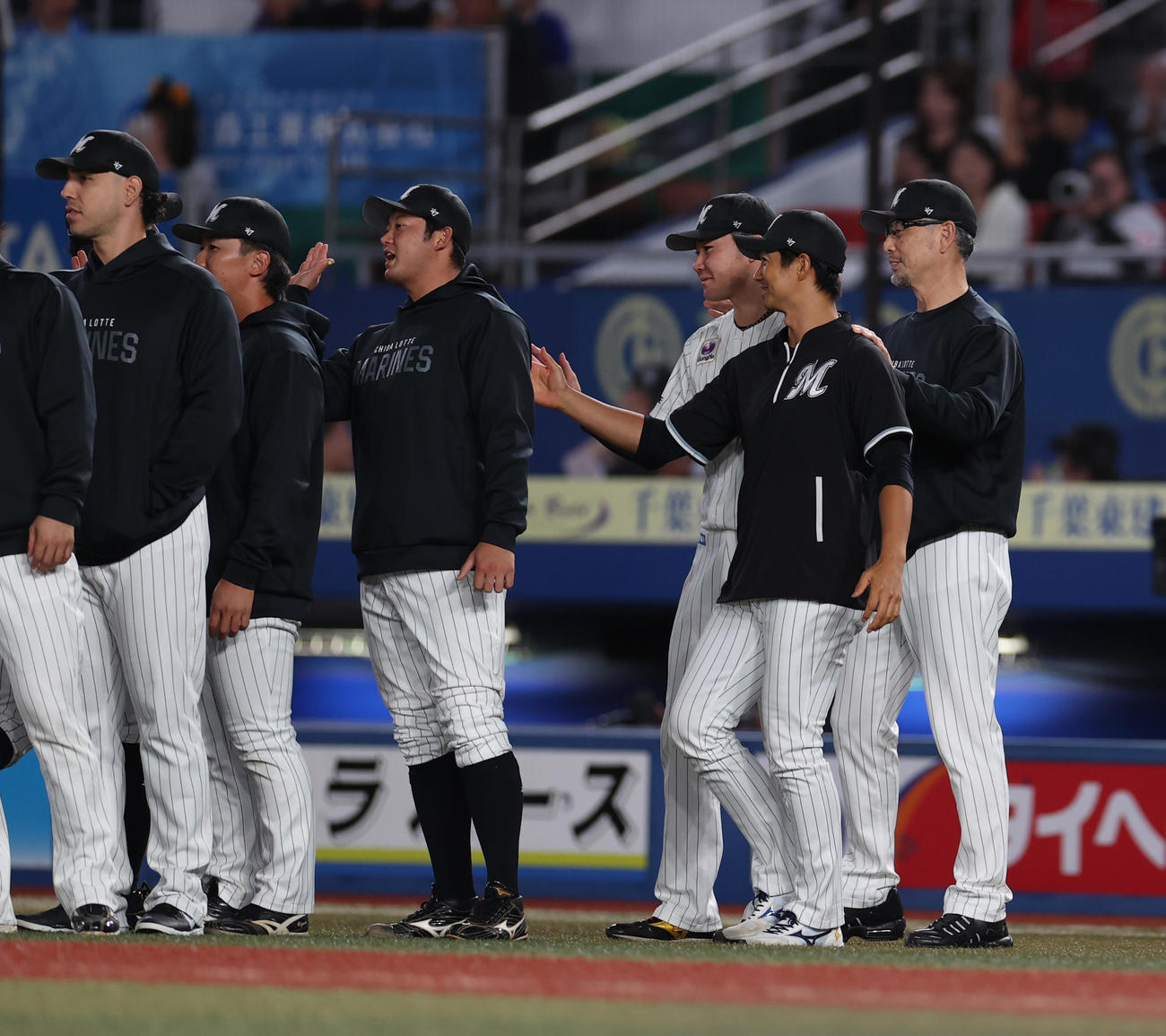 ロッテ対西武　勝利が決まり広池康と唐川の肩を揉む吉井監督（右端）（撮影・水谷安孝）