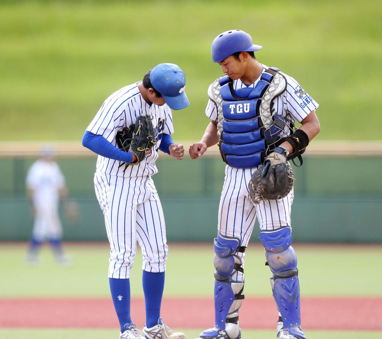 東北福祉大対東北学院大　9回バッテリータイムでグータッチする東北学院大の堀川（左）と田村（撮影・木村有優）