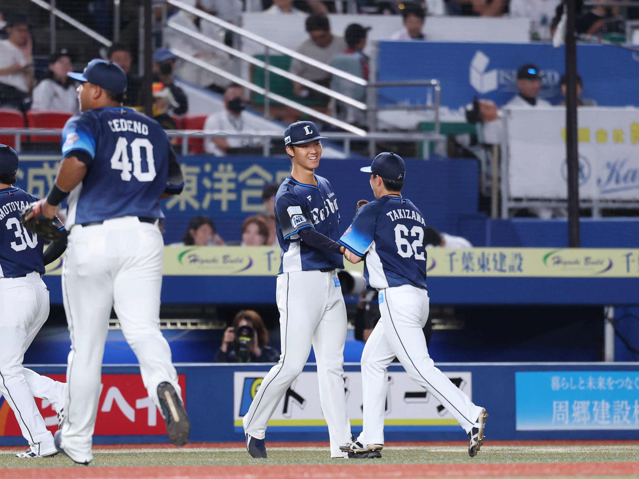 ロッテ対西武　4回裏ロッテ　ピンチをしのぎ滝沢（右）とタッチを交わす菅井（中央）（撮影・増田悦実）