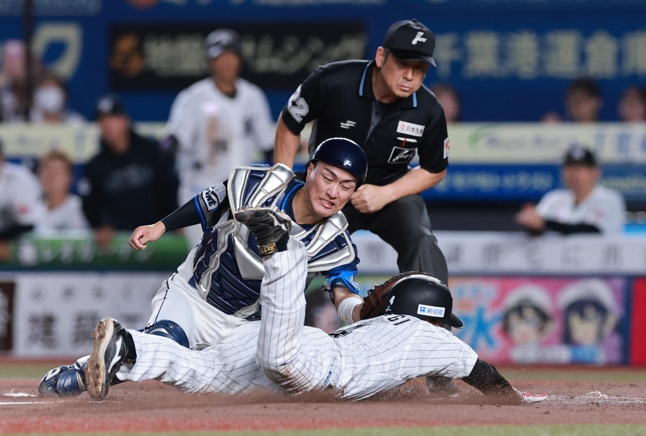 ロッテ対西武　3回裏ロッテ無死一塁、西川の左二塁打で本塁をつくもアウトとなる友杉。捕手古市（撮影・野上伸悟）