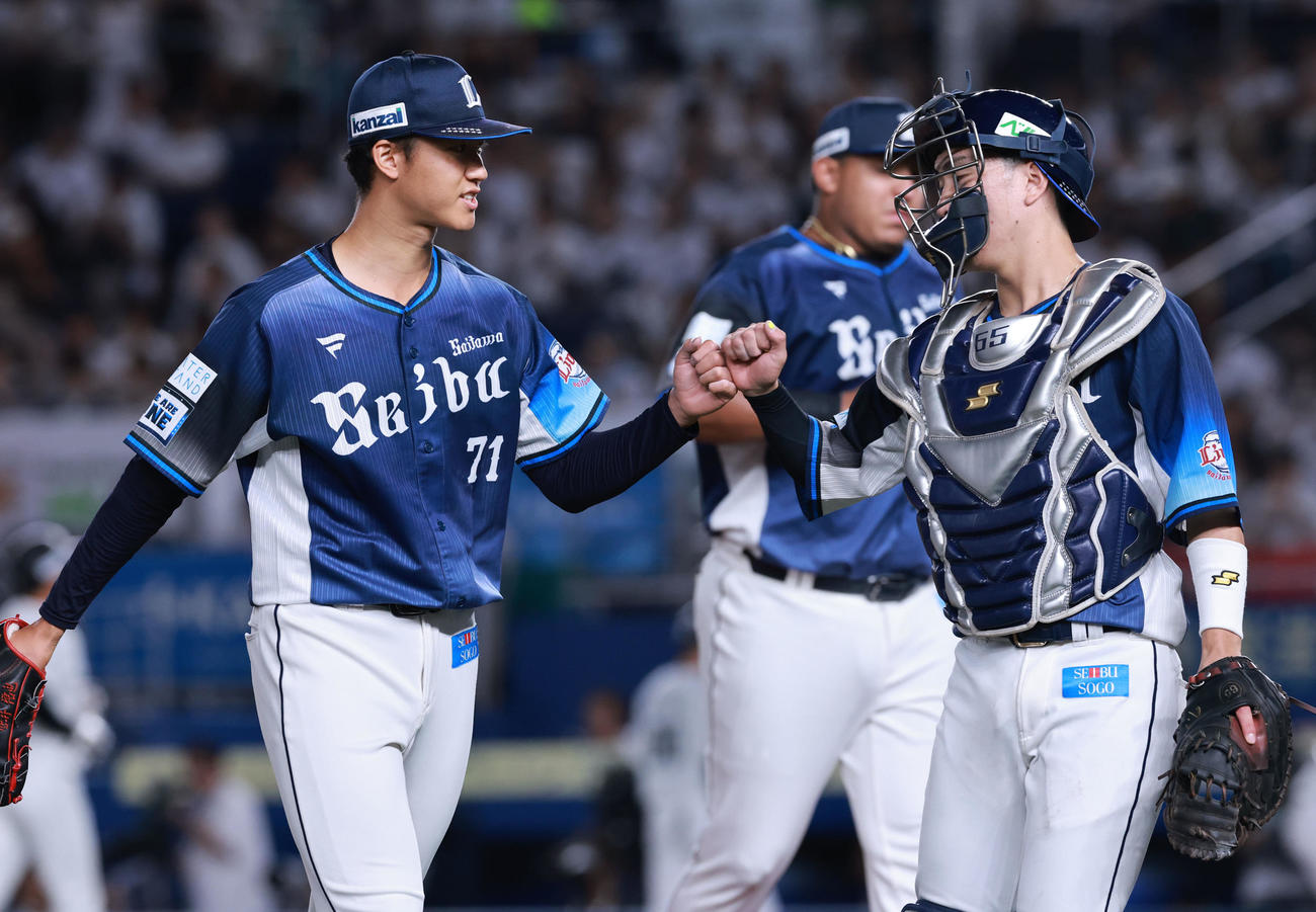 ロッテ対西武　3回裏を終え古市（右）と喜ぶ西武菅井（撮影・野上伸悟）