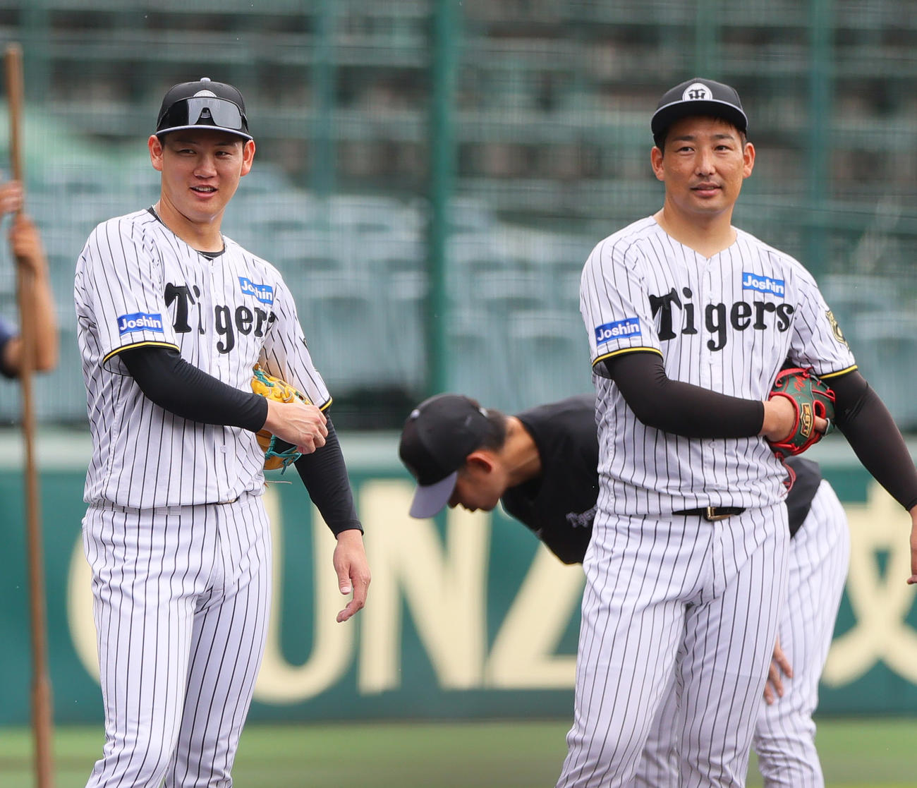 投内連係でリラックスした表情を見せる阪神及川（左）と岩崎（撮影・上山淳一）