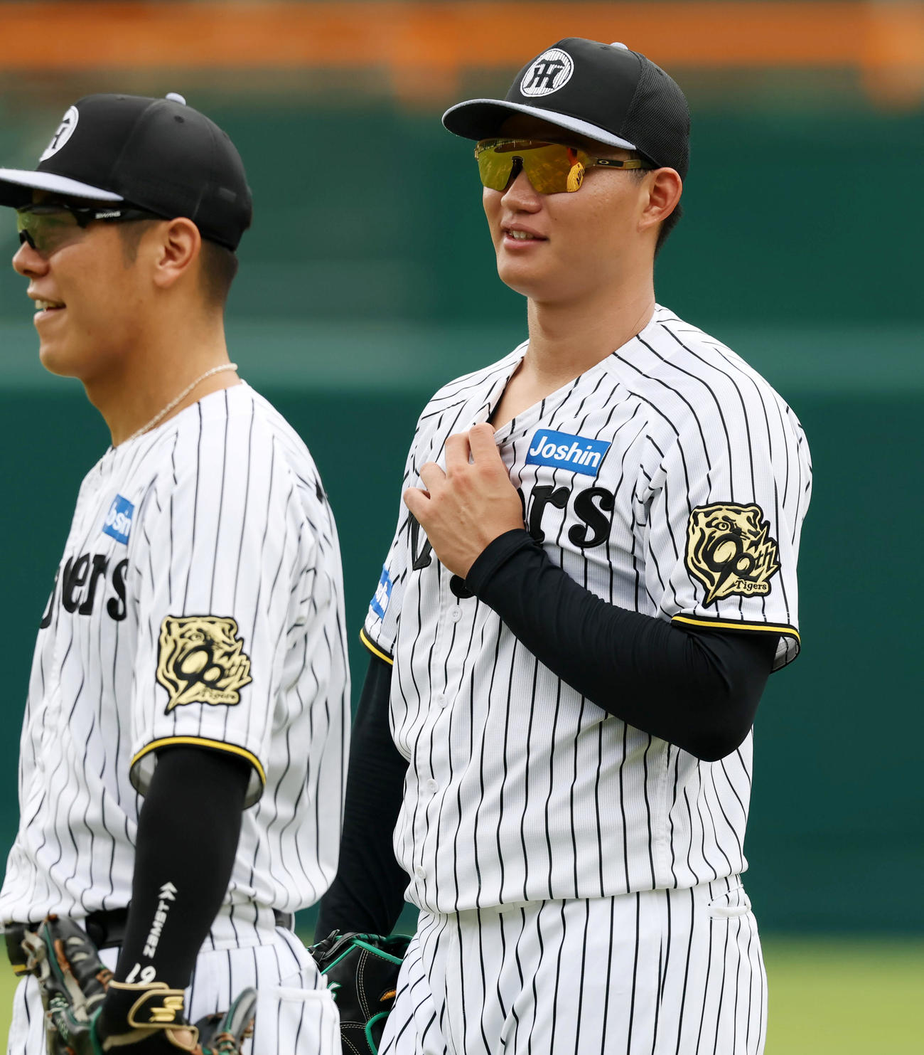 投内連係プレーの練習中、守備位置でユニホームの首元に指をかける森下。左は豊田（撮影・加藤哉）