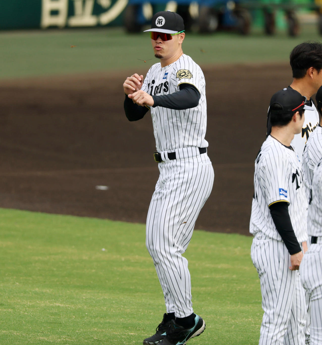 練習開始前、目の前を飛ぶトンボを捕まえようとする佐藤輝（撮影・加藤哉）